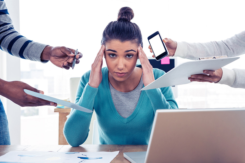 Female adult with hands on temples looking stressed
